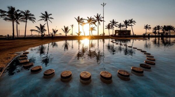 A view of the sun setting over a pool.