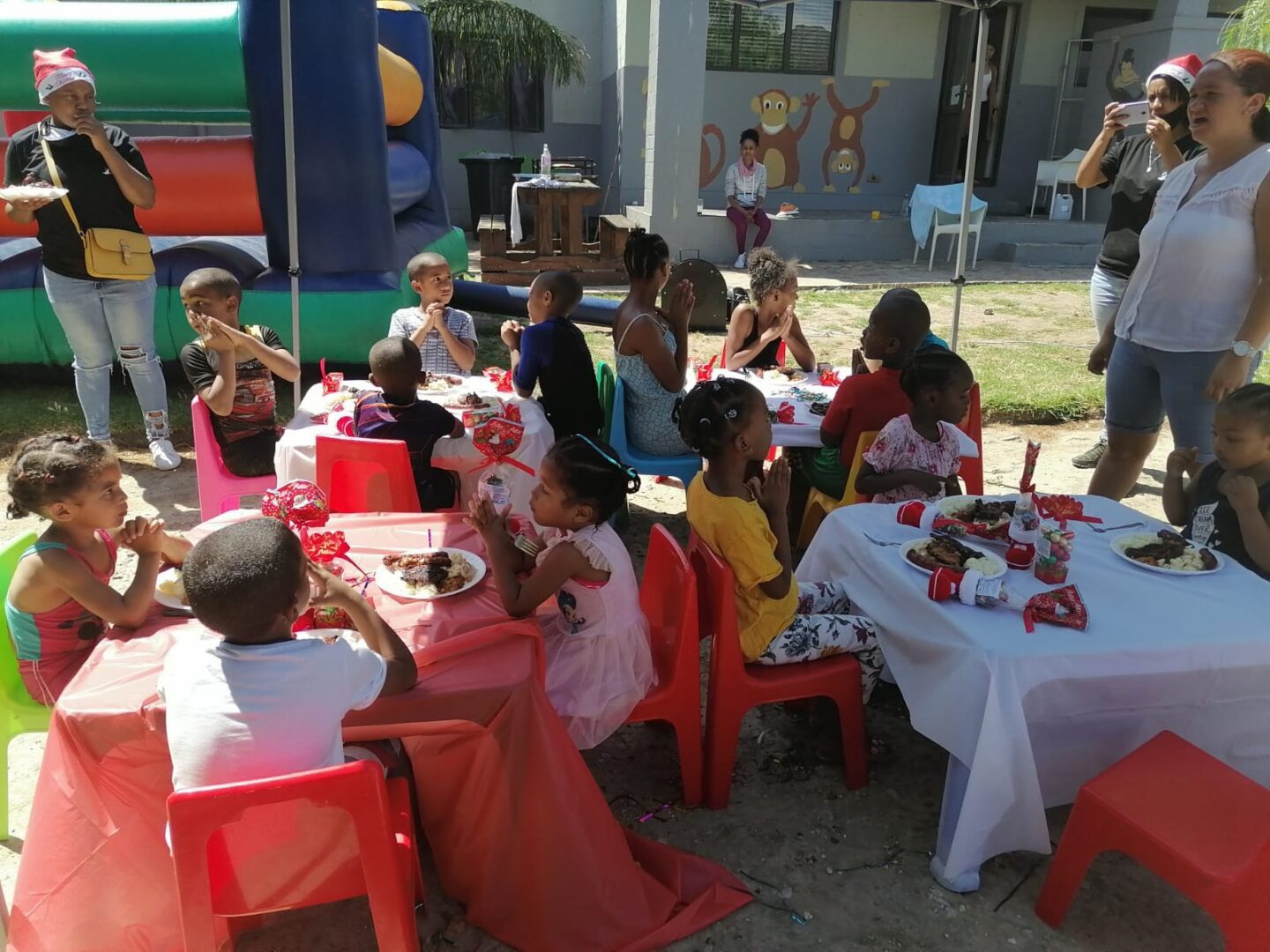 A group of children sitting at tables with food.