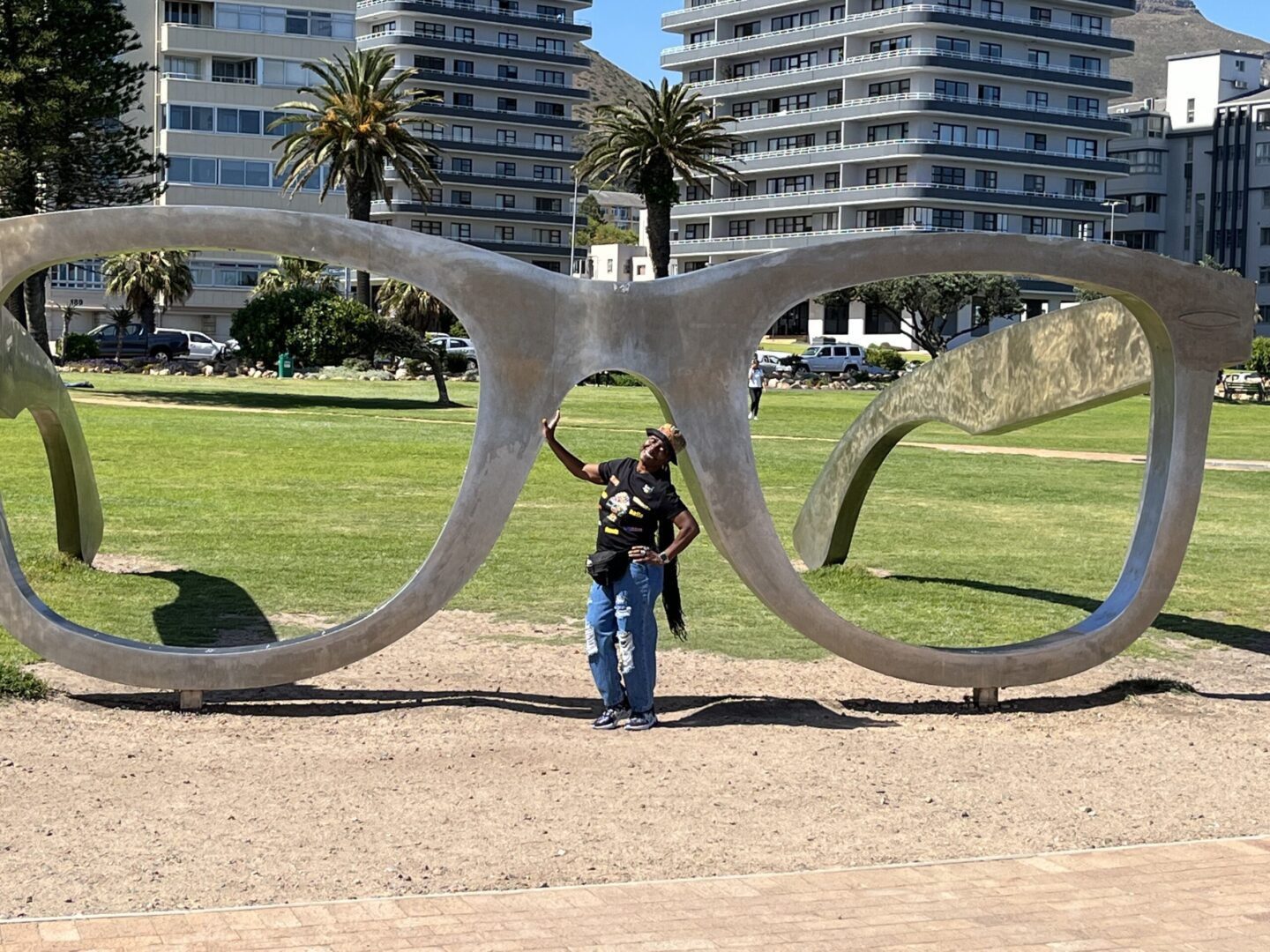 A woman standing in front of an outdoor sculpture.