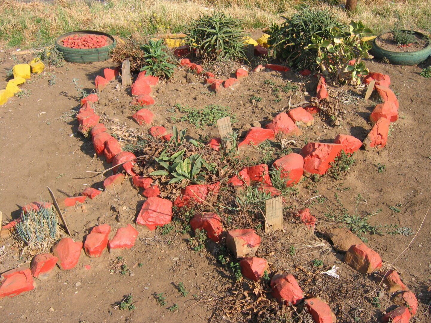 A pile of watermelon sitting in the dirt.