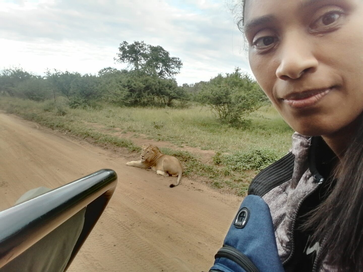 A young person taking a selfie with an animal in the background.