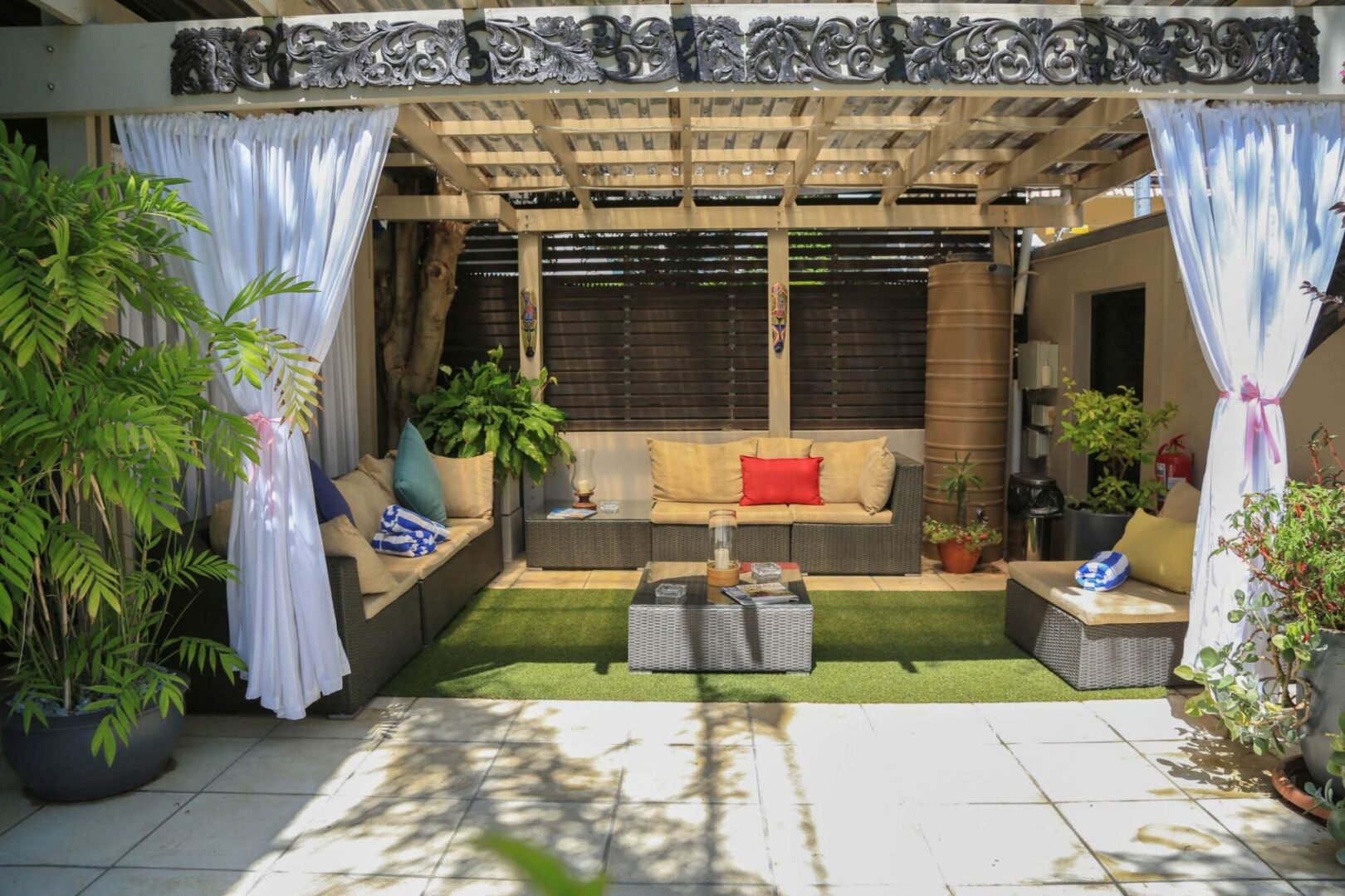 A patio with furniture and plants in it.
