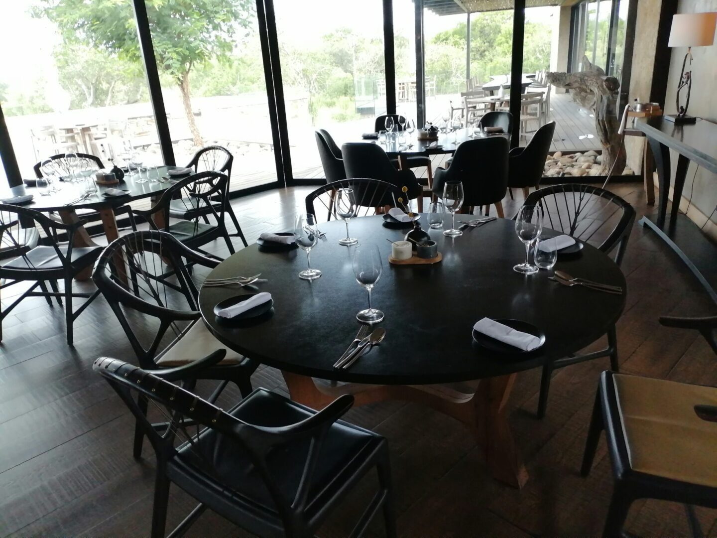A restaurant with tables and chairs set up for dinner.