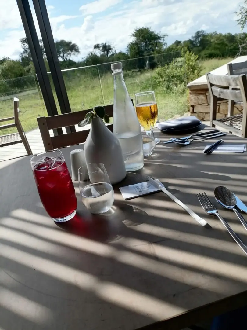 A table with drinks and utensils on it.