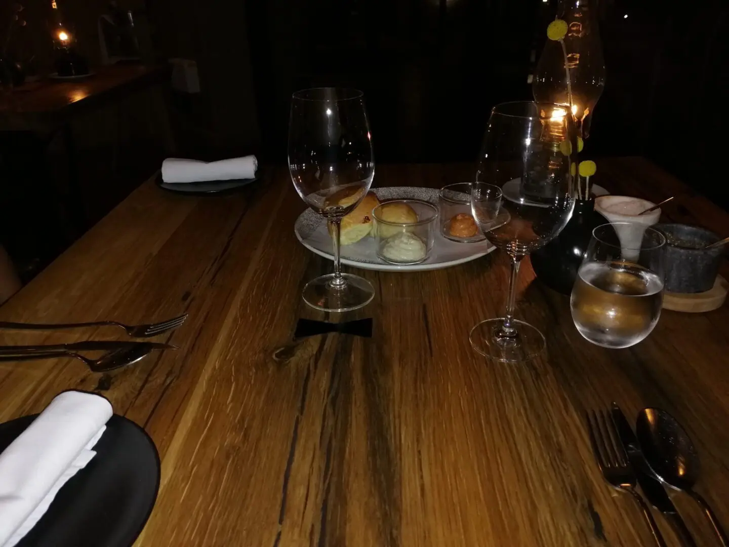 A wooden table with wine glasses and plates on it