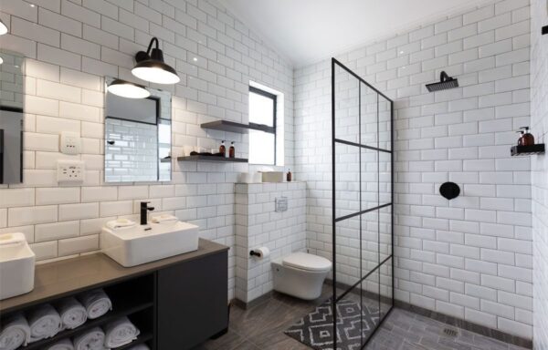 A bathroom with white walls and black tile.