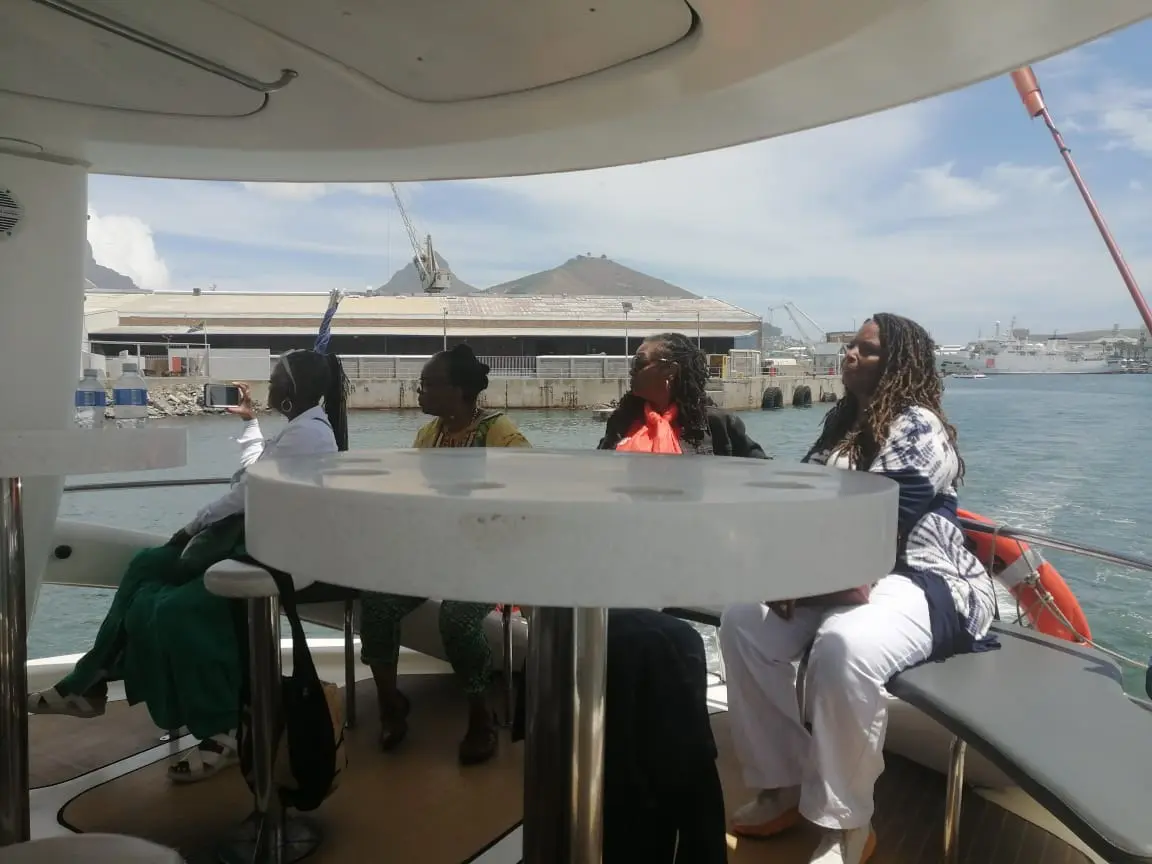 A group of people sitting at the table on a boat.