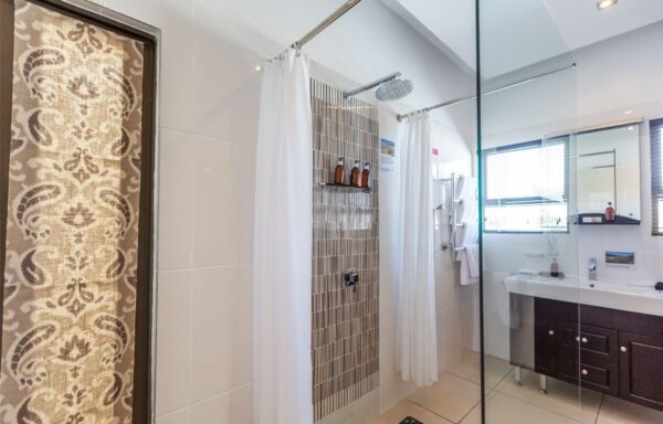 A bathroom with a shower and tiled walls