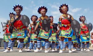 A group of women in colorful outfits are marching.