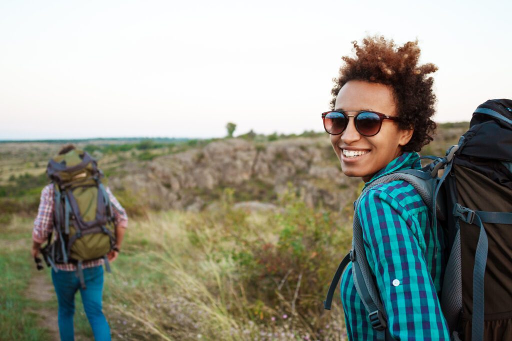 Smiling hiker with backpack on scenic trail